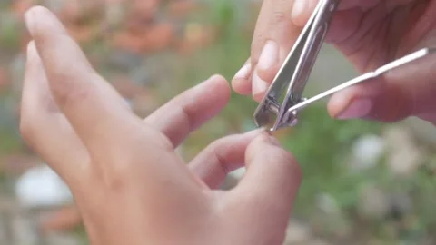 A man is cutting his fingernails using a metal nail clipper Stock Footage 333343239