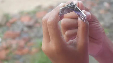 A man is cutting his fingernails using a metal nail clipper Stock Footage 333343255
