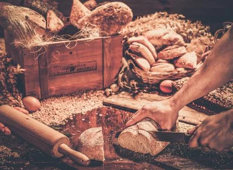 Man cutting homemade bread  on a table Stock Photos
