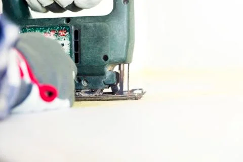 Man cutting kitchen countertop using electric jigsaw. Home improvement, renov Stock Photos