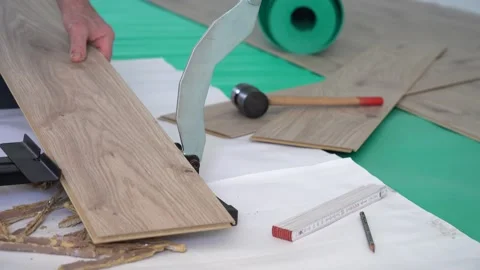 Man is cutting laminate with laminate scissors. preparing to install laminate. Stock Footage 148400703
