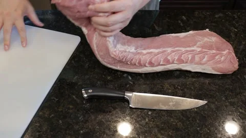 Man Cutting Large Pork Meat In A Kitchen Stock Footage 138380596