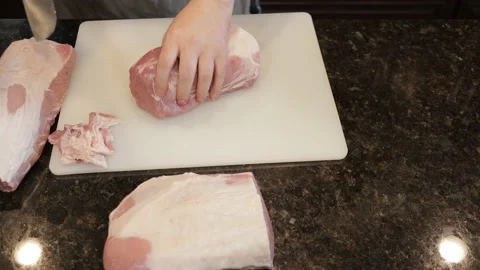 Man Cutting Large Pork Meat In A Kitchen Stock Footage 138380600