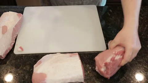 Man Cutting Large Pork Meat In A Kitchen Stock Footage 138380633