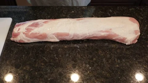 Man Cutting Large Pork Meat In A Kitchen Stock Footage 138380699