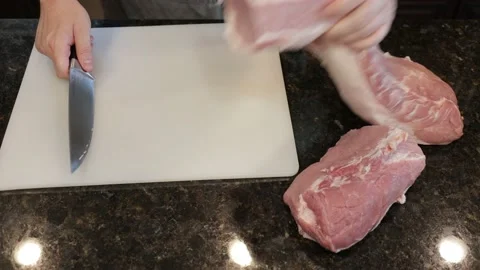 Man Cutting Large Pork Meat In A Kitchen Stock Footage 138380725