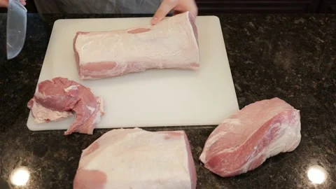 Man Cutting Large Pork Meat In A Kitchen Stock Footage 138381032