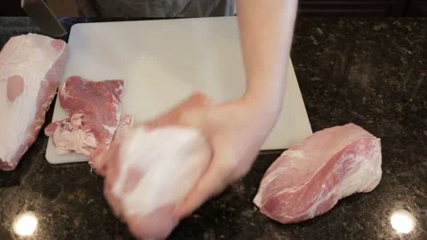 Man Cutting Large Pork Meat In A Kitchen Stock Footage 138381149