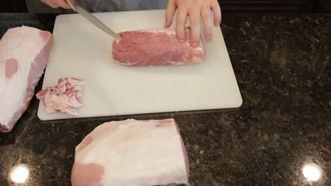 Man Cutting Large Pork Meat In A Kitchen Stock Footage 138381152