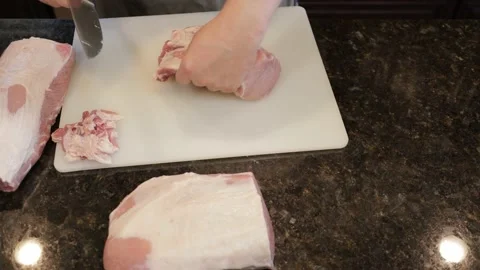 Man Cutting Large Pork Meat In A Kitchen Stock Footage 138381177