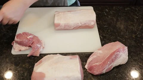 Man Cutting Large Pork Meat In A Kitchen Stock Footage 138381287