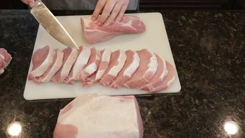 Man Cutting Large Pork Meat In A Kitchen Stock Footage 138381799