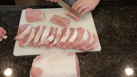Man Cutting Large Pork Meat In A Kitchen Stock Footage 138382490