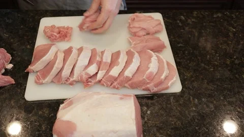 Man Cutting Large Pork Meat In A Kitchen Stock Footage 138384600