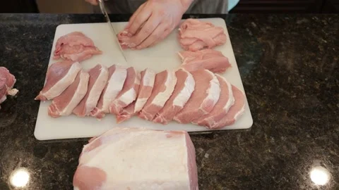 Man Cutting Large Pork Meat In A Kitchen Stock Footage 138384622