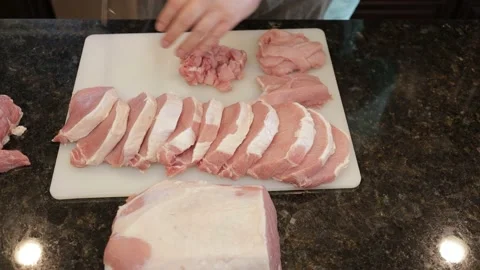 Man Cutting Large Pork Meat In A Kitchen Stock Footage 138384659