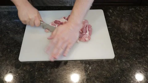 Man Cutting Large Pork Meat In A Kitchen Stock Footage 138384660