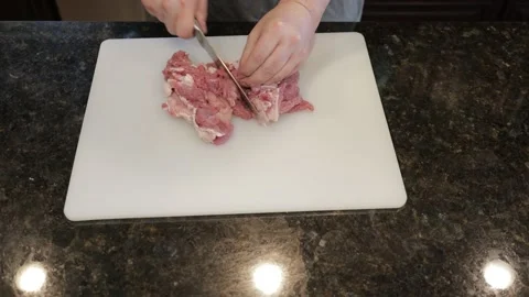 Man Cutting Large Pork Meat In A Kitchen Stock Footage 138384675