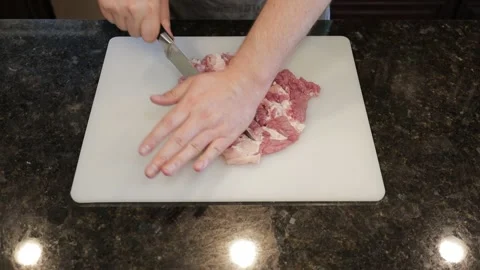 Man Cutting Large Pork Meat In A Kitchen Stock Footage 138384936
