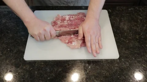 Man Cutting Large Pork Meat In A Kitchen Stock Footage 138385061
