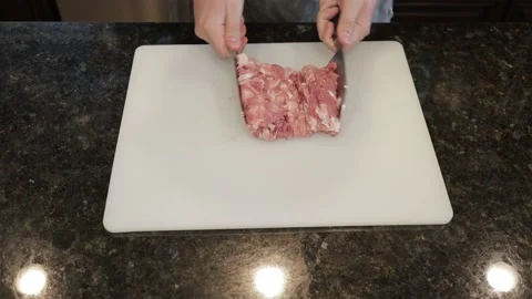 Man Cutting Large Pork Meat In A Kitchen Stock Footage 138385201