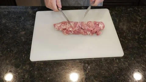 Man Cutting Large Pork Meat In A Kitchen Stock Footage 138385327