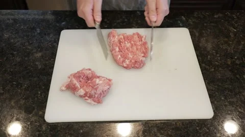 Man Cutting Large Pork Meat In A Kitchen Stock Footage 138385552