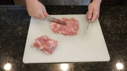 Man Cutting Large Pork Meat In A Kitchen Stock Footage 138385657