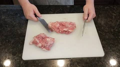 Man Cutting Large Pork Meat In A Kitchen Stock Footage 138385739