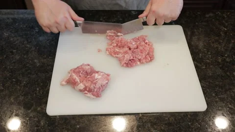 Man Cutting Large Pork Meat In A Kitchen Stock Footage 138386097