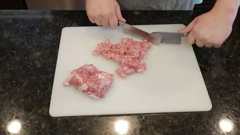 Man Cutting Large Pork Meat In A Kitchen Stock Footage 138386143