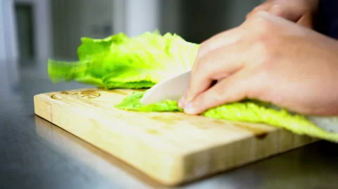 Man Cutting Lettuce on Board Cutting with Ceramic White Knife - Close Up 4K R Stock Footage 59787186