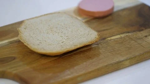 A man cutting a loaf of bread with a bread knife. Stock Footage 83602154