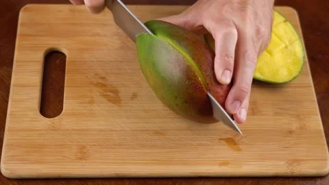 Man cutting mango fruit, selective focus. How to cut mango video tutorial Stock Footage 144738395