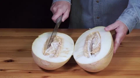 Man cutting melon into two halves Stock Footage 314787582