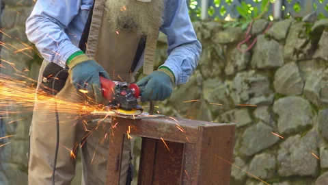 Man Cutting Metal with Angle Grinder Outdoors 스톡 동영상 336234749