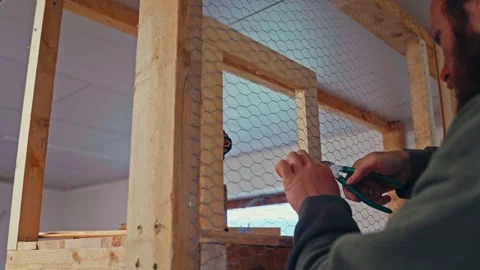 Man Is Cutting Metal Mesh Using Pliers To Make A Small Opening In A Wooden Stock Footage 336901812
