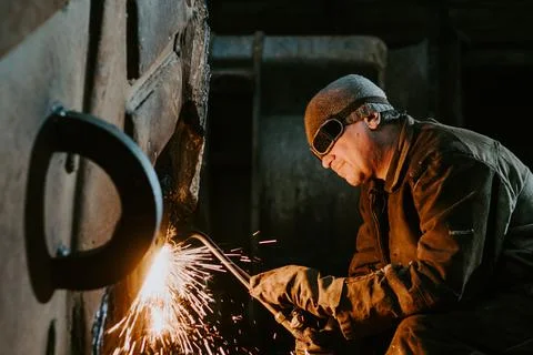 A man cutting metal with a plasma cutter Stock Photos