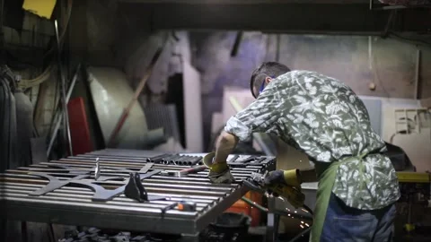 Man cutting metal using grinding machine in hangar Stock Footage 139589473