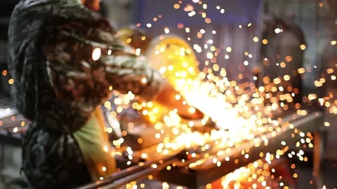 Man cutting metal using grinding machine in hangar Stock Footage 139593249