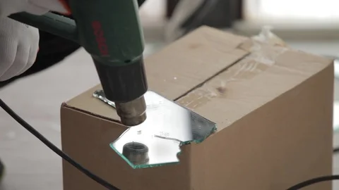 A man cutting mirror with the dryer for cutting mirror Stock Footage 86476176