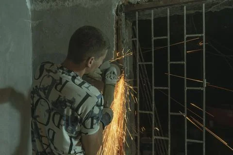 A man cutting an old gate in a underground Photos