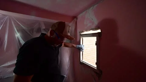 Man cutting an old window frame with a grinder during renovation Video stock 347640630