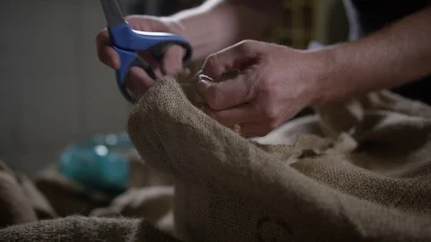 Man cutting open burlap sack of coffee beans Stock Footage 94363495