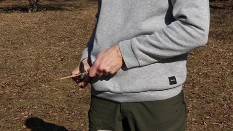 Man cutting or carving a stick with one knife. Stock Footage 253074802