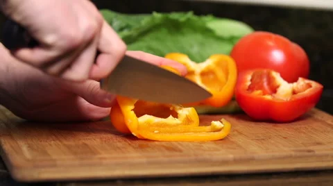 Man cutting orange bell pepper close up Stock Footage 61403182