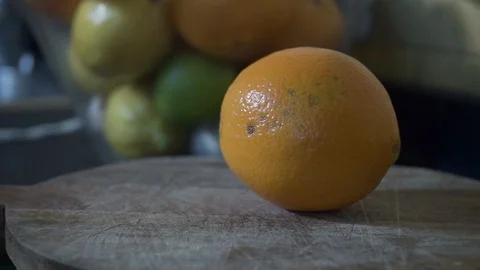 Man cutting an orange in half. Stock Footage 129865447