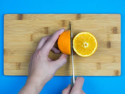 Man cutting an orange Fotos de archivo