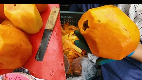 Man cutting papayas in the streets horizontal view with smooth motion. Stock Footage 238364923