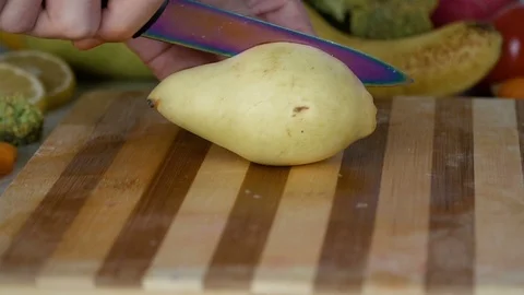 Man is cutting pear on cutting board Stock Footage 98201407